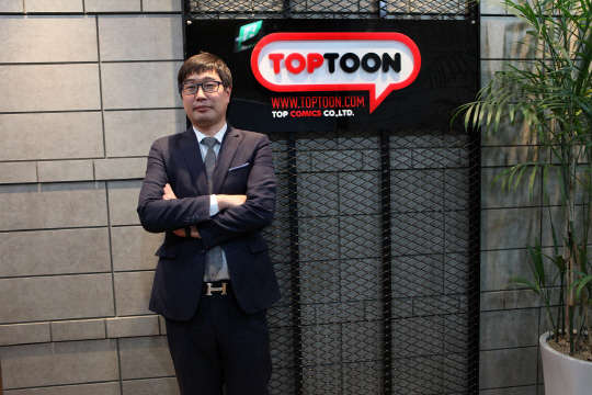 웹툰 벤처 '탑코믹스'는 설립 8개월 만에 매출 100억원을 돌파하며 비상한 관심을 받고 있다. 이젠 아시아 시장 공략까지 나선 회사는 가입자 2억명 모집이 단기 목표라고 밝혔다. 김춘곤 탑코믹스 대표가 서울 구로디지털단지에 위치한 본사에서 포즈를 취하고 있다.  탑코믹스 제공